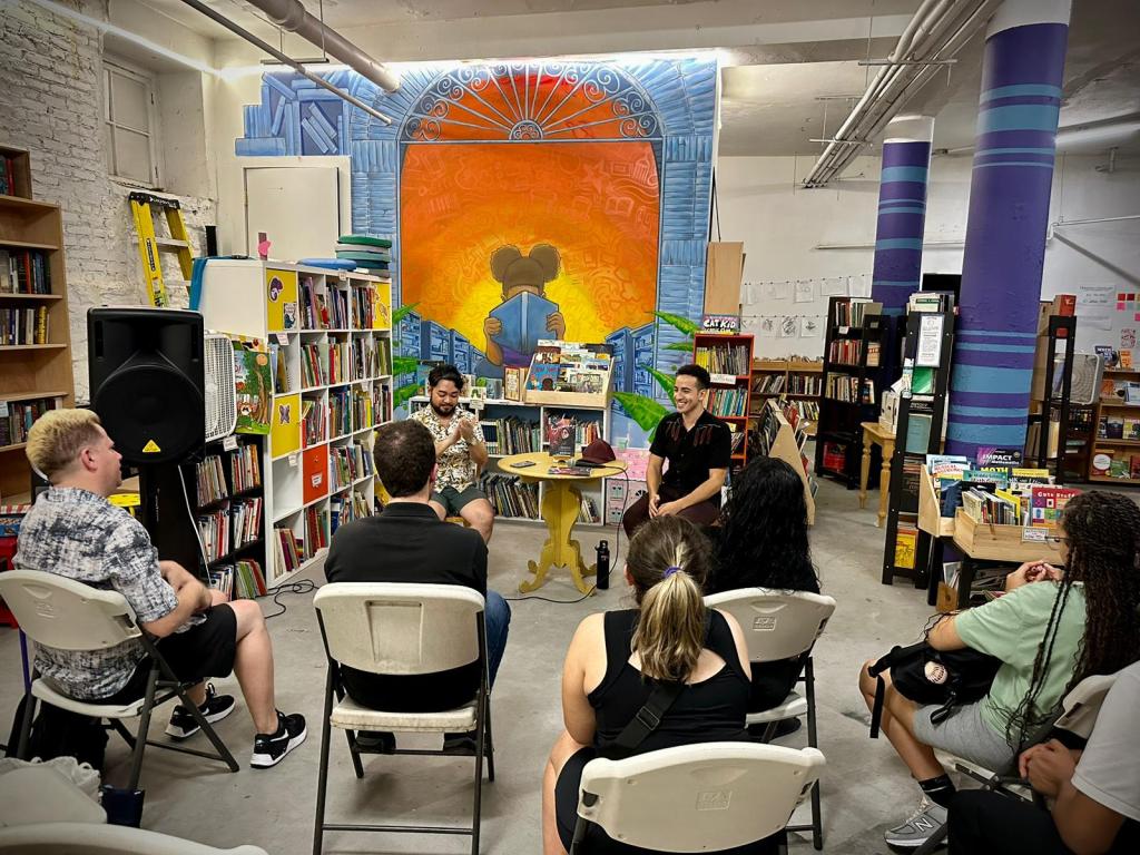 E.G. Condé with Victor Manibo conversing in front of a crowd gathered in New York City