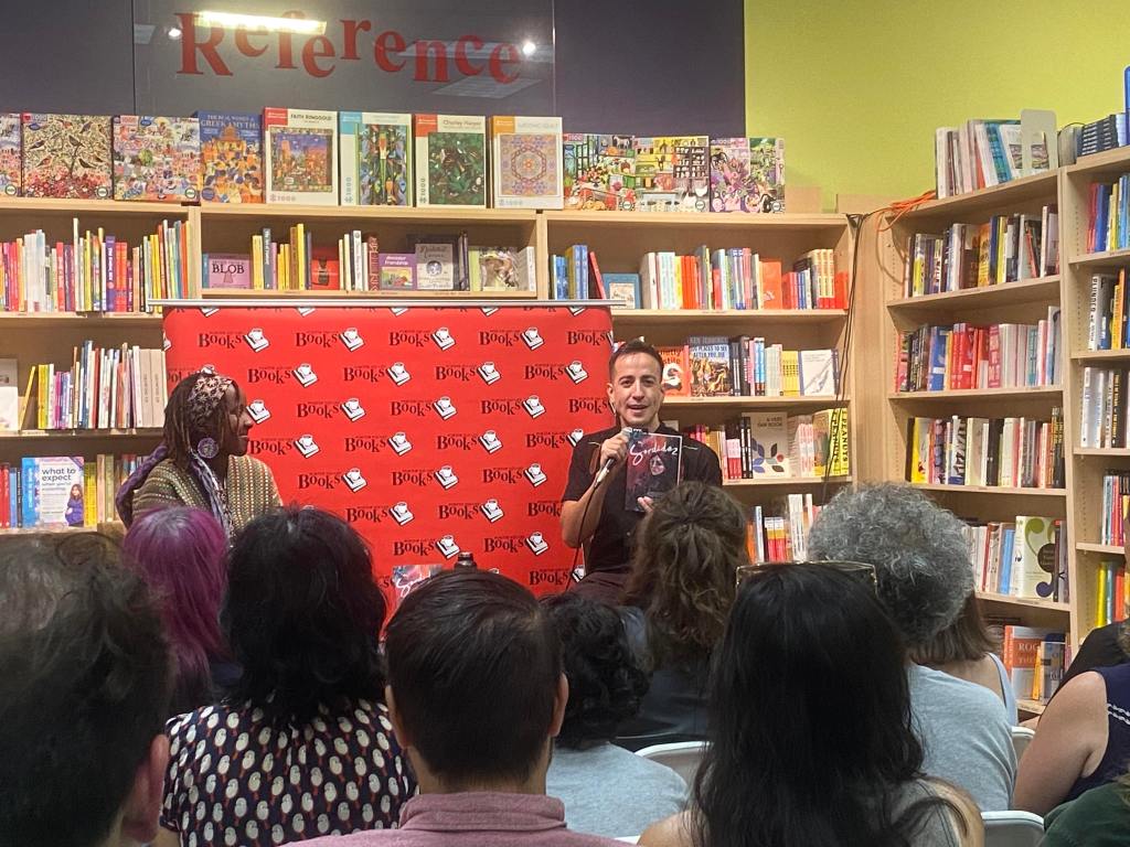 E.G. Condé with Shingai Njeri Kagunda sitting in front of a crowd gathered at Porter Square Books in Cambridge, MA